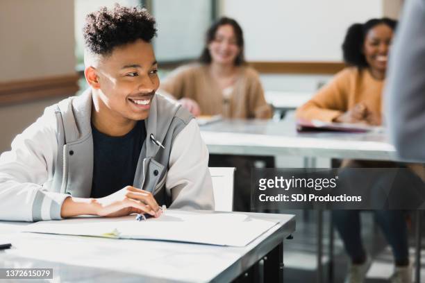 confident male high school student smiles during class - high school bildbanksfoton och bilder