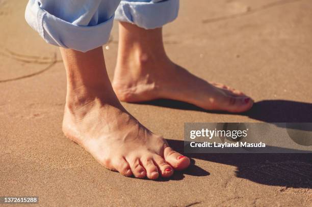 bare feet on beach sand - womans bare feet fotografías e imágenes de stock