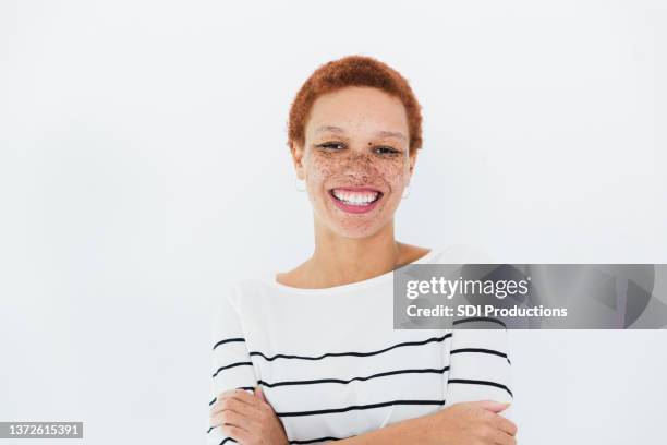 businesswoman poses for photo with arms crossed and big smile - freckle stock pictures, royalty-free photos & images