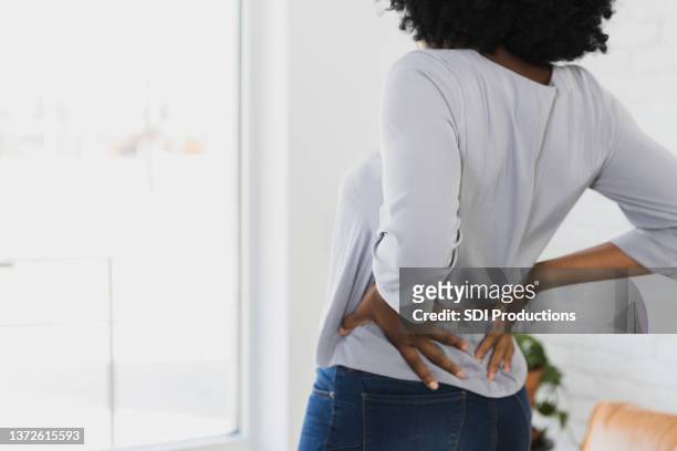 mujer irreconocible - back pain fotografías e imágenes de stock