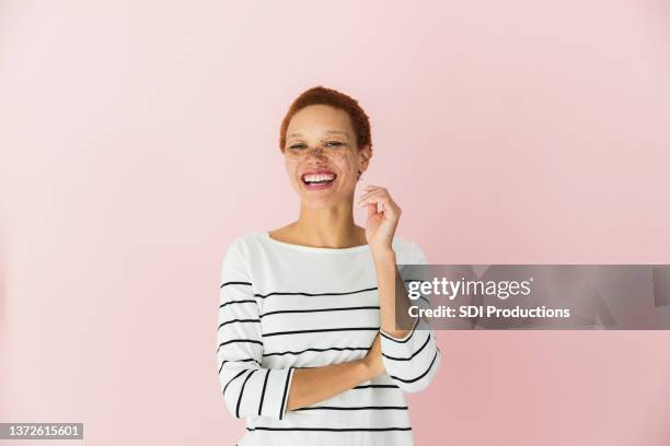 mujer mediana adulta risueña - pink background fotografías e imágenes de stock