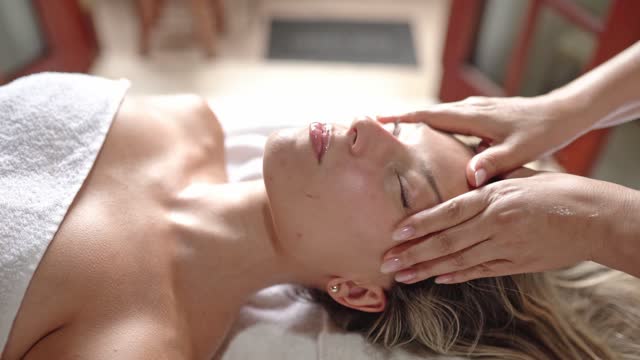 Young woman getting a face massage in a health spa