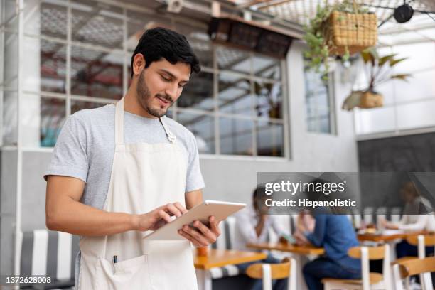 portrait of a waiter working at a restaurant using a tablet - waiter using digital tablet stock pictures, royalty-free photos & images