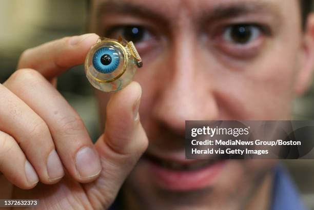 Team of research engineers at MIT has been working on a retinal implant project. Shawn Kelly, research engineer, holds up a retinal implant...