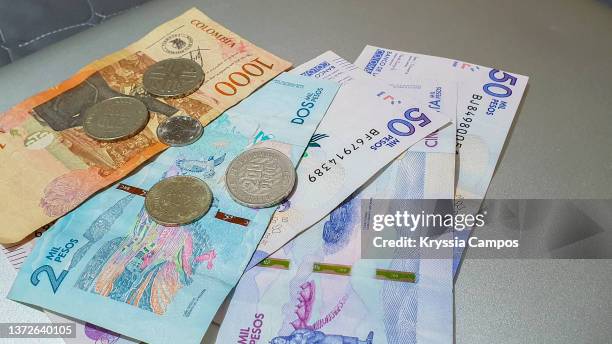 pile of colombian pesos bills and coins - seleccion colombia stock-fotos und bilder