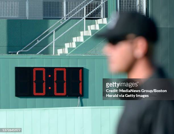 Game official looks toward the pitcher's mound between innings as a clock built into the outfield wall ticks down the seconds during a spring...
