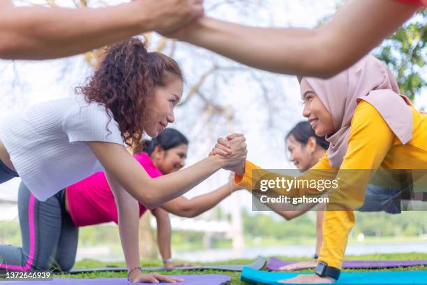 multiethnisches sportteam sportliches paar kooperiert beim push-up-krafttraining in der natur - push up japanese stock-fotos und bilder