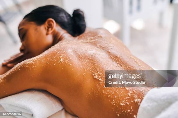 shot of an attractive young woman getting an exfoliating massage at a spa - body scrub bildbanksfoton och bilder