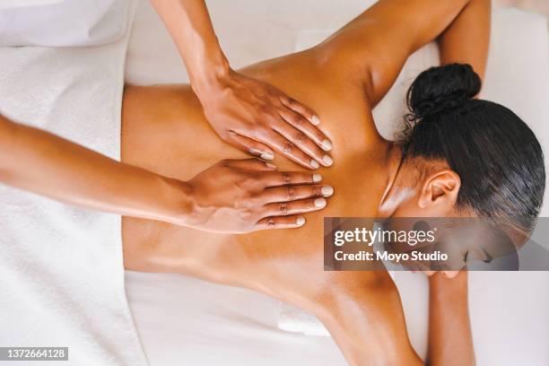 foto de una atractiva joven recibiendo un masaje en un spa - black massage therapist fotografías e imágenes de stock