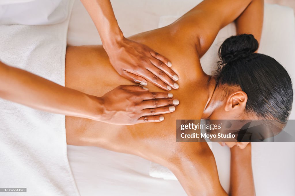 Photo d’une jolie jeune femme se faisant masser dans un spa