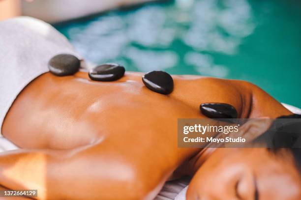 shot of a woman getting a hot stone massage at a spa - lastone terapi bildbanksfoton och bilder