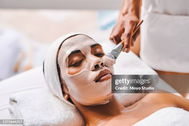 foto de una atractiva joven que se hace un tratamiento facial en un spa de belleza - máscara facial fotografías e imágenes de stock