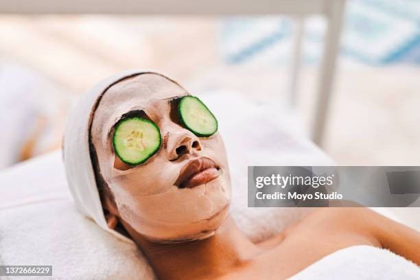 scatto di una giovane donna attraente che ottiene un trattamento viso in una spa di bellezza - cucumber foto e immagini stock