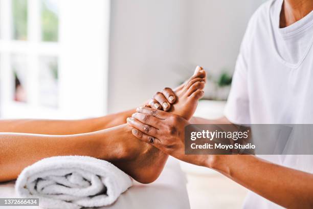 aufnahme einer unkenntlichen jungen frau, die in einem beauty-spa massiert wird - reflexology stock-fotos und bilder