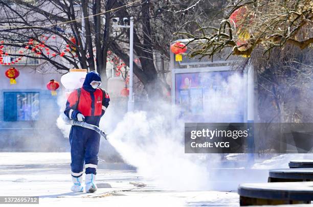 Staff member disinfects a residential community under lock down on February 24, 2022 in Hohhot, Inner Mongolia Autonomous Region of China.