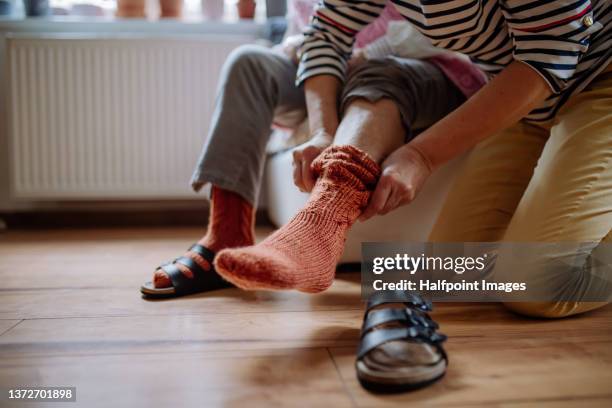 close-up of healthcare worker putting on warm socks to senior woman. - roupa quente imagens e fotografias de stock