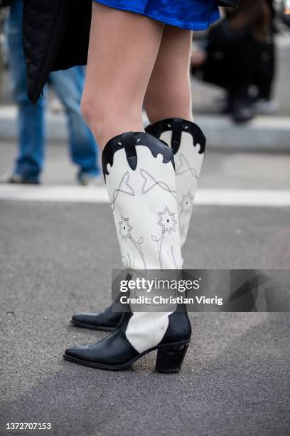 Guest is seen wearing cowboy boots outside Prada fashion show during the Milan Fashion Week Fall/Winter 2022/2023 on February 24, 2022 in Milan,...