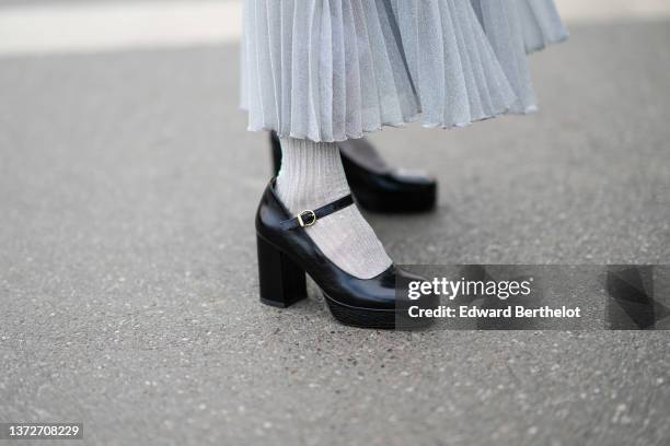Xiayan wears a high waist pale gray pleated / accordion glitter midi skirt, pale gray glitter socks, black shiny leather block heels ballerinas,...