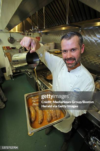 Nuno Alves, the chef at Tavolo pours fat onto his 'Nuno's spicy sausage', which they are cooked in, at his restaurant. Tuesday, March 18, 2014.