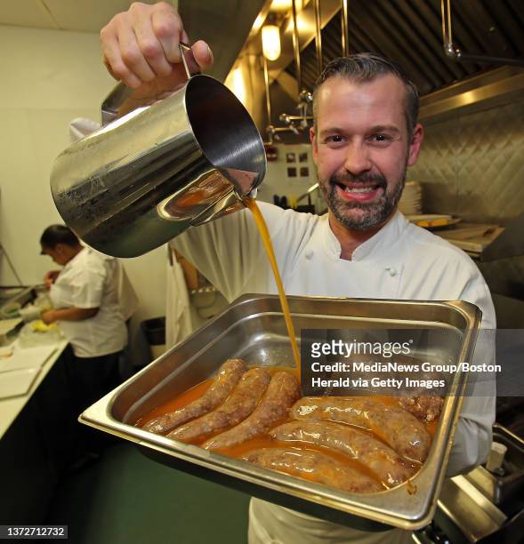 Nuno Alves, the chef at Tavolo pours fat onto his 'Nuno's spicy sausage', which they are cooked in, at his restaurant. Tuesday, March 18, 2014.
