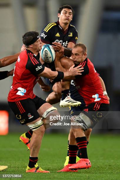 Thomas Umaga-Jensen of the Highlanders challenges Scott Barrett of the Crusaders and Tom Christie of the Crusaders for the ball during the round two...