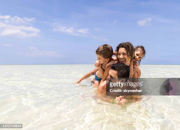 famiglia felice godendo nella giornata estiva in mare poco profondo. - human pyramid foto e immagini stock