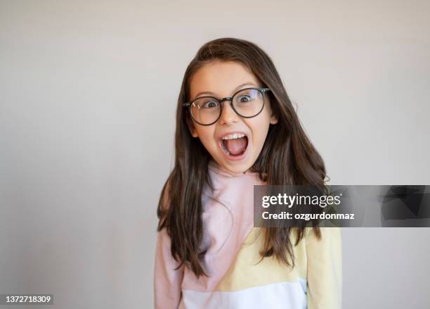 nerd little girl wearing a large glasses making a funny face - child prodigy stock pictures, royalty-free photos & images