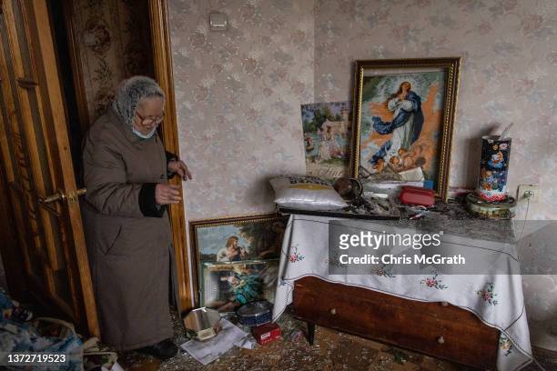 Resident checks on a damaged room of her apartment in a residential block hit by an early morning missile strike on February 25, 2022 in Kyiv,...