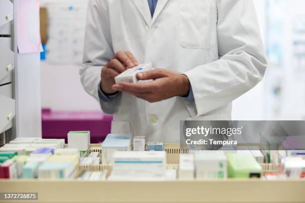 a pharmacist is organizing pillboxes in a drugstore drawer. - pharmacy stockfoto's en -beelden