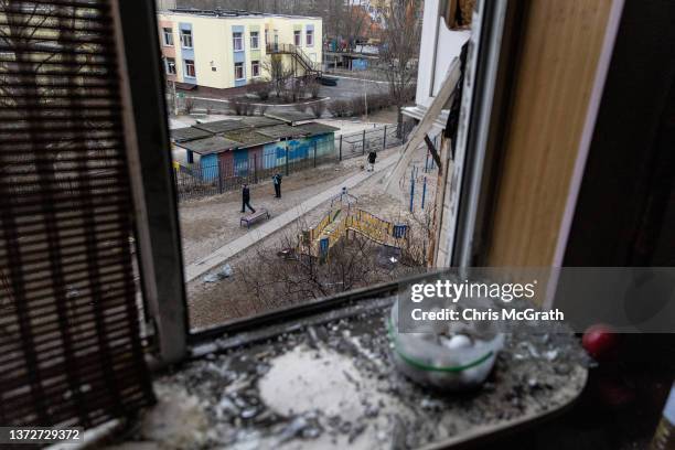 People take photographs of the exterior of a residential block hit by an early morning missile strike on February 25, 2022 in Kyiv, Ukraine....