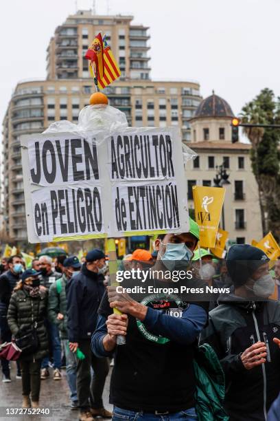 Man with a banner reading 'Young farmer in danger of extinction' in a rally for the "survival" of the Valencian countryside, in the Plaza San...