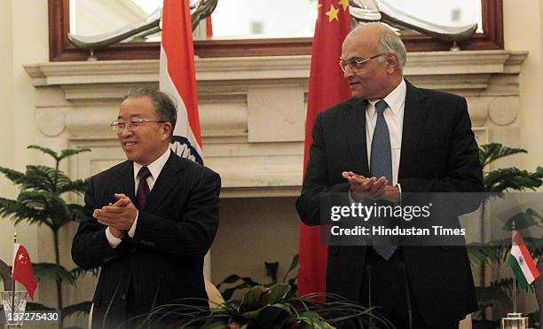 National Security Adviser Shivshankar Menon and Chinese State Councilor Dai Bingguo applaud during the signing of an agreement at the conclusion of...