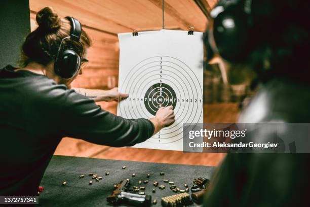 un instructeur d’armes à feu marque les résultats d’une tireuse sur un champ de tir - cible militaire photos et images de collection