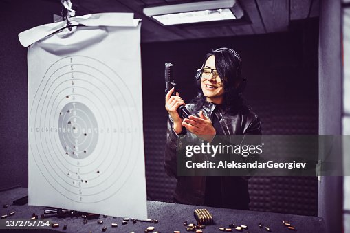 Smiling Female Having Fun On Gun Range And Reloading Pistol For Another Try At Target