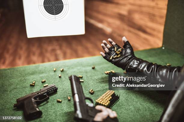 male showing all bullet cartridges he fired from guns on range - bullet hole in wood stock pictures, royalty-free photos & images