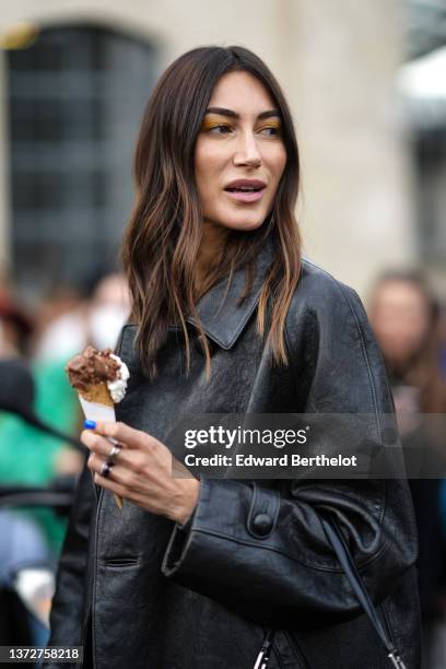 Giorgia Tordini wears a black shiny leather coat from Prada, a black shiny varnished leather Cleo handbag from Prada, outside the Prada fashion show,...