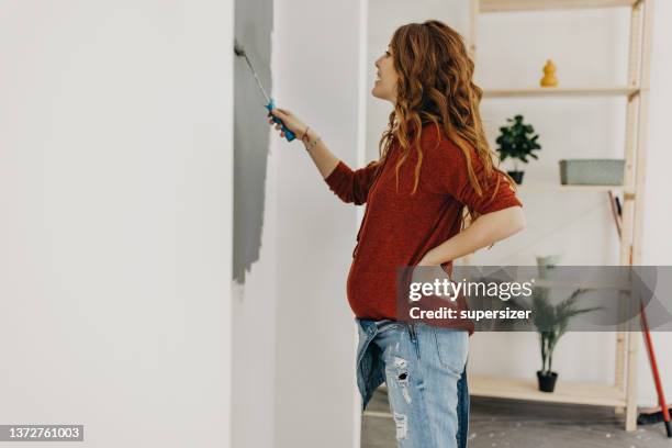 junge schwangere frau malt kinderzimmer - renovieren zimmer streichen stock-fotos und bilder