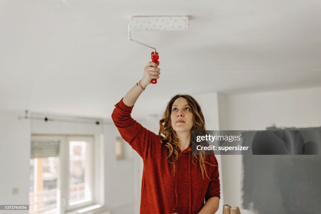 Young woman painting room
