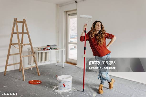 joven embarazada pintando sala de guardería - trabajo desde casa fotografías e imágenes de stock