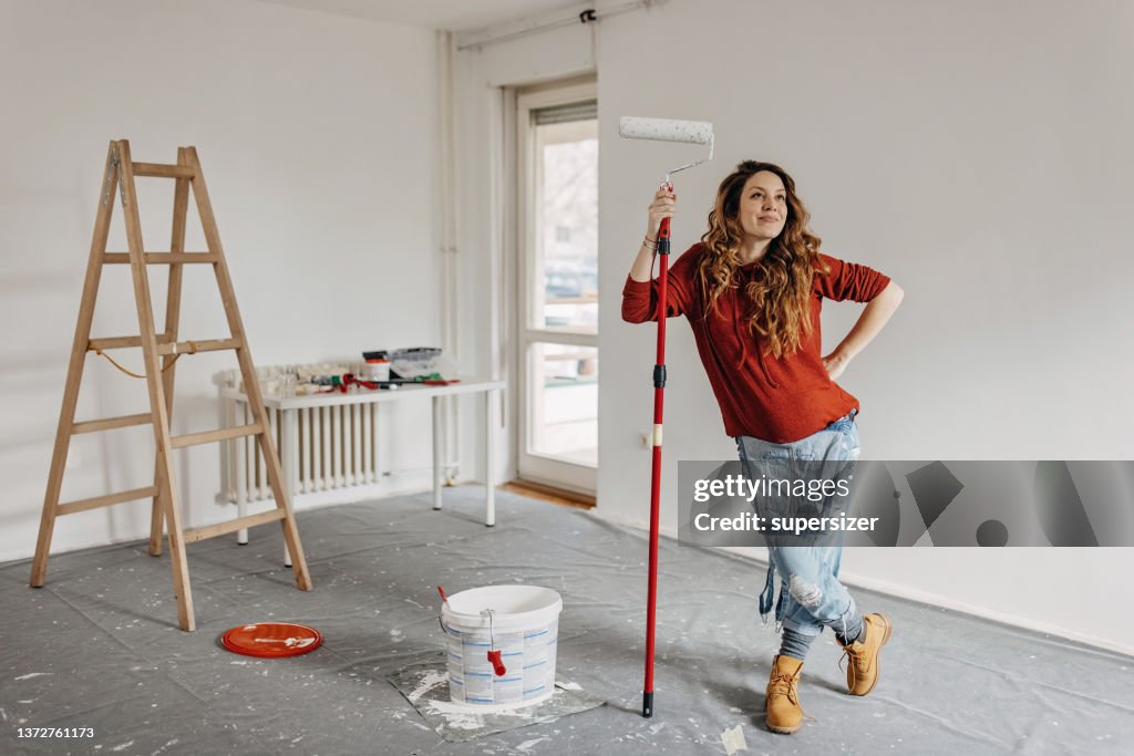 Jovem grávida pintando sala de berçário