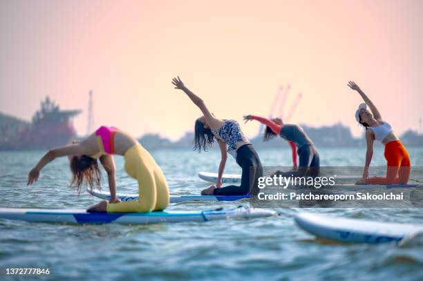 floating yoga - woman stretching sunset stock-fotos und bilder