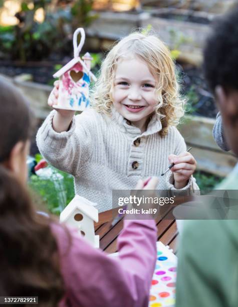 little girl showing off her painted birdhouse - bird feeder stock pictures, royalty-free photos & images