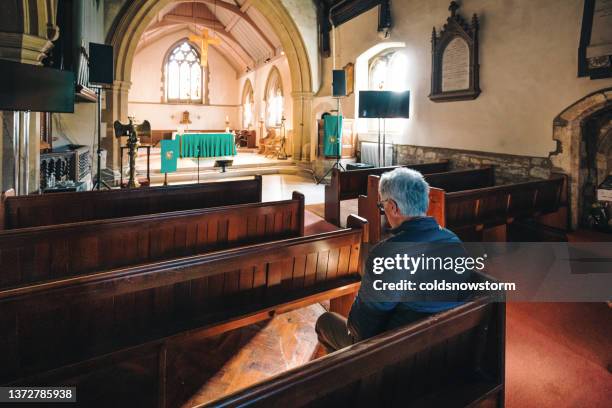 senior man praying in ancient anglican church - worshipper bildbanksfoton och bilder