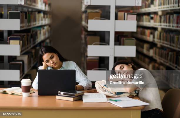 female student being tired at library - choice student stockfoto's en -beelden