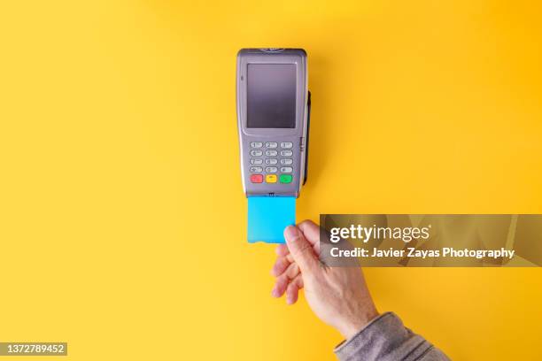 credit card pos terminal on yellow background - credit card reader stock pictures, royalty-free photos & images