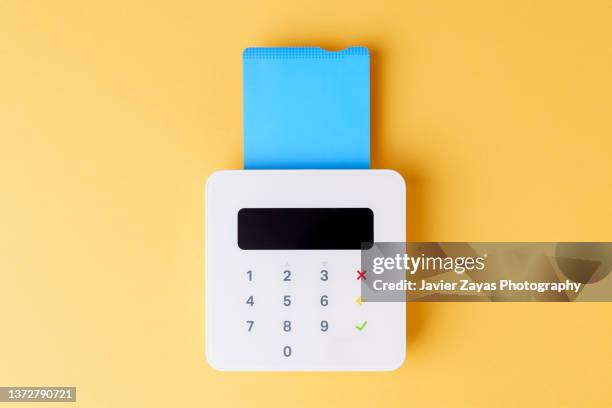 credit card pos terminal on yellow background - pinning stock pictures, royalty-free photos & images