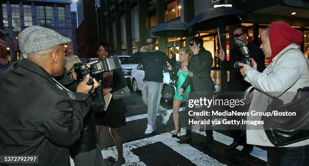 Members of "Your Paparazzi for Hire" work thier magic on Justine McCarthy and her "escort" Tim Robishaw along Newbury Street in Boston. Friday, April...