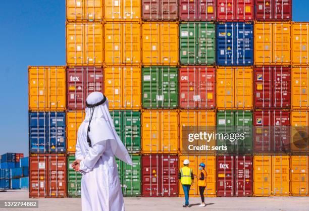 arab businessman checking and standing outside on a large commercial dock during pandemic - commercial dock stockfoto's en -beelden
