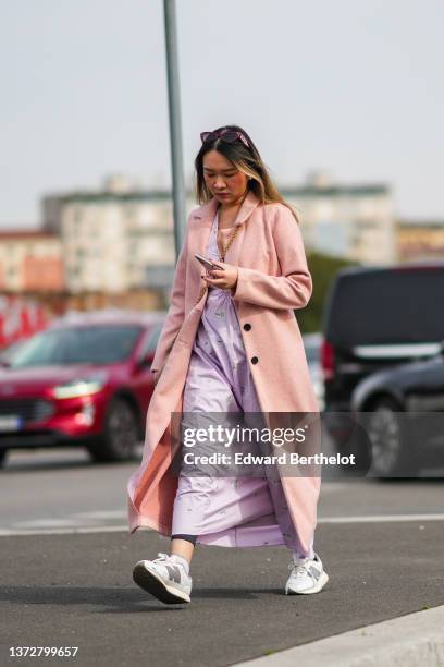 Guest wears purple vintage sunglasses from Miu Miu, a pale purple with green flower print pattern V-neck / cut-out waist midi dress, a brown shiny...