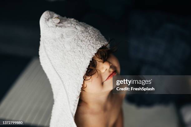 a close up shot of an anonymous cute little girl smiling after having a bath - kids taking a shower stockfoto's en -beelden